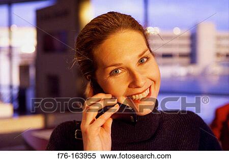 Woman at airport with cell phone View Large Photo Image Stock Photography - Woman at airport with cell phone. Fotosearch