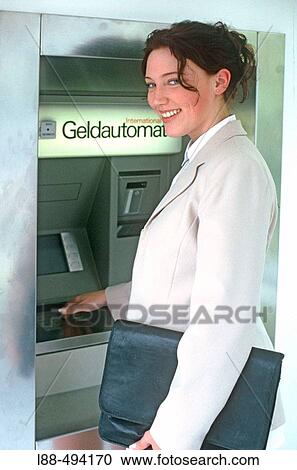 Stock Image - Woman at bank machine.. Fotosearch