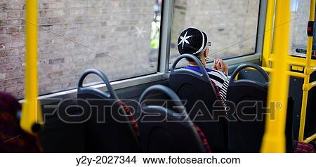 Picture - Woman at bus with weeds bonnet and reflection, in London, UK.. Fotosearch