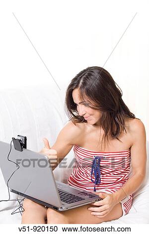 Stock Image - Woman at home with laptop communicating by cam. Fotosearch