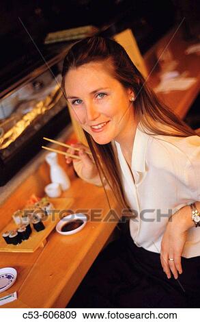 Stock Photo - Woman at sushi restaurant. Fotosearch