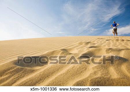 Woman at the top of a sand dune with her footprints in the foreground View Large Photo Image Stock Photograph - Woman at the top of a sand dune with her footprints in the foreground. Fotosearch