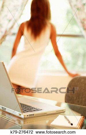 Woman at window with laptop View Large Photo Image Stock Image - Woman at window with laptop. Fotosearch