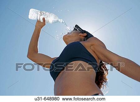 Woman athlete pours water on her face View Large Photo Image Stock Image - Woman athlete pours water on her face. Fotosearch