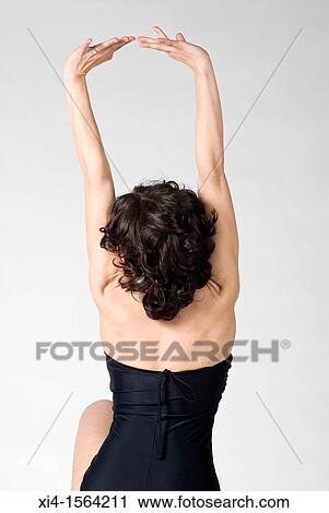Stock Image - Woman back straighten arms Bare shoulders She has a diamond ring in her hand. Fotosearch