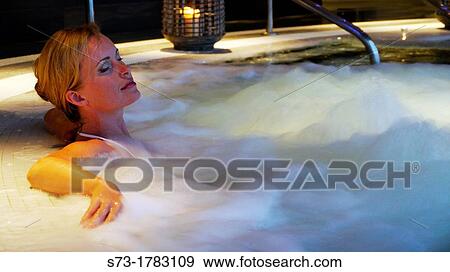 Stock Photo - Woman bathing in jacuzzi of spa center. Fotosearch