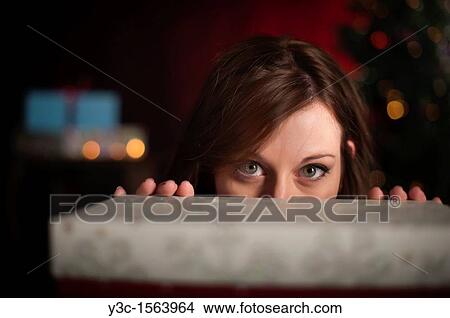 Woman behind gift box at Christmas time View Large Photo Image Picture - Woman behind gift box at Christmas time. Fotosearch