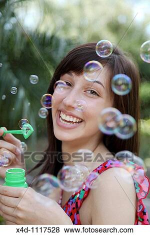 Stock Photo - Woman blowing bubbles. Fotosearch