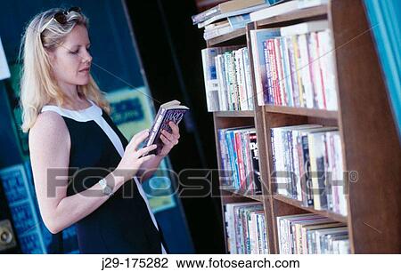 Stock Image - Woman browsing at bookstore. Fotosearch