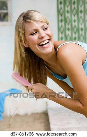Woman brushing her hair happy View Large Photo Image Stock Photograph - Woman brushing her hair happy. Fotosearch