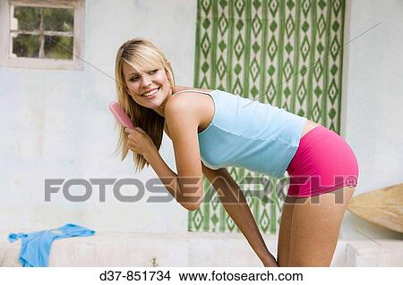 Woman brushing her hair View Large Photo Image Picture - Woman brushing her hair. Fotosearch