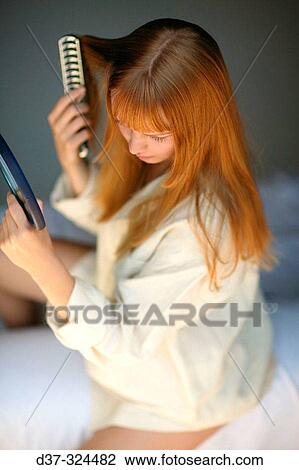 Stock Image - Woman brushing her hair. Fotosearch