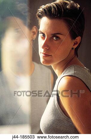 Woman by a glass window View Large Photo Image Stock Image - Woman by a glass window. Fotosearch