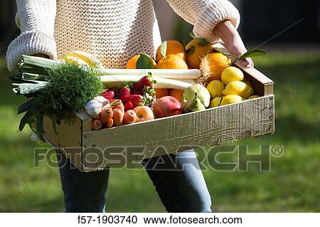 Woman carrying a wooden crate of healthy fruit & vegetables View Large Photo Image Stock Image - Woman carrying a wooden crate of healthy fruit & vegetables. Fotosearch