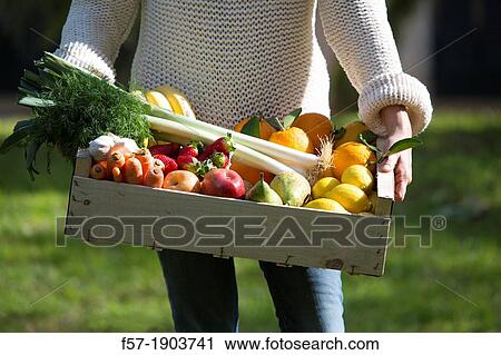 Woman carrying a wooden crate of healthy fruit & vegetables View Large Photo Image Stock Image - Woman carrying a wooden crate of healthy fruit & vegetables. Fotosearch