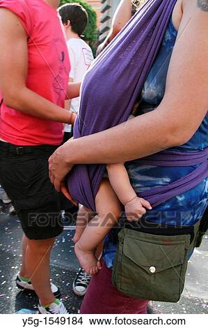 woman carrying baby in a sling in city town View Large Photo Image Picture - woman carrying baby in a sling in city town. Fotosearch