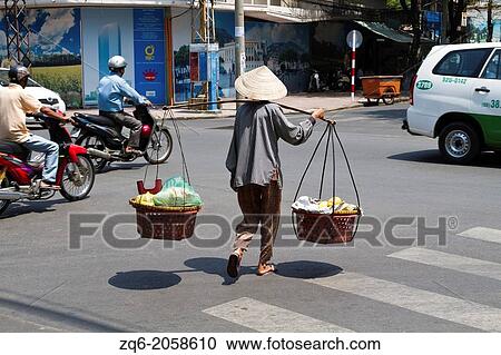 Woman carrying Food over the Street in Ho Chi Minh City, Vietnam. View Large Photo Image Stock Image - Woman carrying Food over the Street in Ho Chi Minh City, Vietnam.. Fotosearch