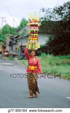 Woman carrying offers to temple during the Galungan Festival. Bali, Indonesia View Large Photo Image Picture - Woman carrying offers to temple during the Galungan Festival. Bali, Indonesia. Fotosearch