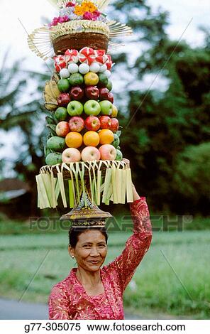 Woman carrying offers to temple during the Galungan Festival. Bali, Indonesia View Large Photo Image Stock Photography - Woman carrying offers to temple during the Galungan Festival. Bali, Indonesia. Fotosearch