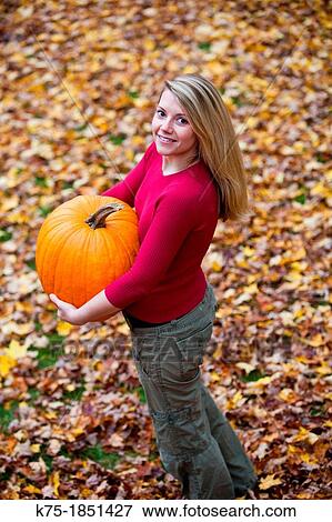 Woman carrying pumpkin View Large Photo Image Stock Photo - Woman carrying pumpkin. Fotosearch