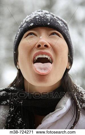 Stock Image - Woman catching snowflake.. Fotosearch