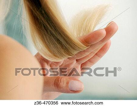Stock Photograph - Woman checking hair. Fotosearch