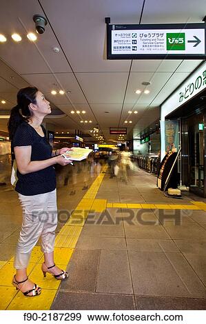 Woman checks train information sign at station in Tokyo, Japan. View Large Photo Image Stock Photo - Woman checks train information sign at station in Tokyo, Japan.. Fotosearch