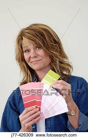 Stock Photo - Woman choosing a colour for painting walls. Fotosearch