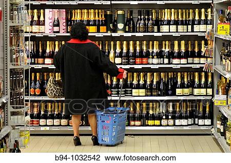 Woman choosing bottles of champagne in a supermarket, France View Large Photo Image Stock Image - Woman choosing bottles of champagne in a supermarket, France. Fotosearch