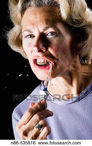 Woman cleaning braces with a water pik View Large Photo Image Stock Photograph - Woman cleaning braces with a water pik. Fotosearch