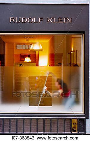 Stock Image - Woman cleaning display window from inside an art gallery. Cologne. Germany. Fotosearch