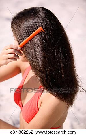 Stock Image - Woman combing her hair. Fotosearch