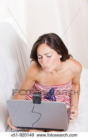 Woman communicating by internet at home View Large Photo Image Stock Photo - Woman communicating by internet at home. Fotosearch