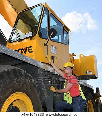 Stock Image - Woman construction worker on a job site. Fotosearch