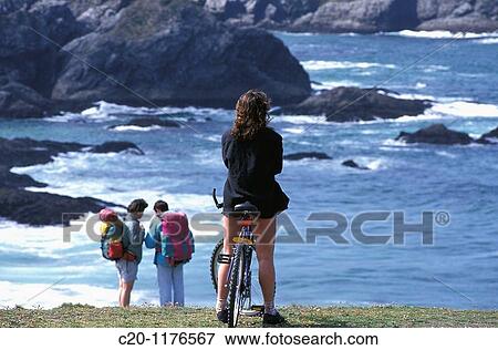 woman cyclist on bike watching the sea and the rocks with 2 tourists in the backgroundBelle Isle en mer56 Brittany France View Large Photo Image Stock Photo - woman cyclist on bike watching the sea and the rocks with 2 tourists in the backgroundBelle Isle en mer56 Brittany France. Fotosearch