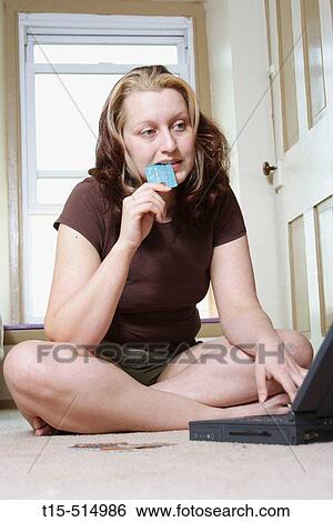 Woman deciding on purchasing over internet View Large Photo Image Stock Photograph - Woman deciding on purchasing over internet. Fotosearch