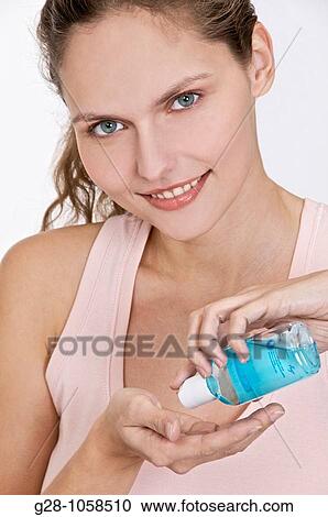 Woman desinfecting her hands with a blue desinfectant View Large Photo Image Stock Image - Woman desinfecting her hands with a blue desinfectant. Fotosearch