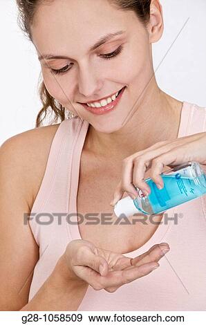 Woman desinfecting her hands with a blue desinfectant View Large Photo Image Stock Photo - Woman desinfecting her hands with a blue desinfectant. Fotosearch