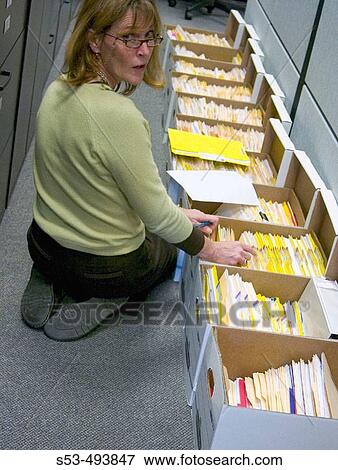 Woman does end of year filing on the floor View Large Photo Image Stock Photo - Woman does end of year filing on the floor. Fotosearch