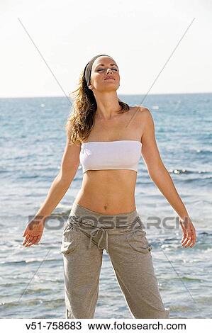 Woman doing exercise by the sea View Large Photo Image Stock Image - Woman doing exercise by the sea. Fotosearch