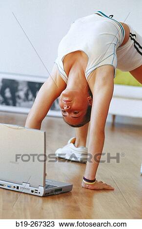 Woman doing exercises and portable computer on the floor View Large Photo Image Stock Image - Woman doing exercises and portable computer on the floor. Fotosearch
