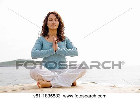 Woman doing yoga in a cliff by the sea View Large Photo Image Stock Image - Woman doing yoga in a cliff by the sea. Fotosearch