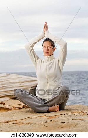 Woman doing yoga in a cliff by the sea View Large Photo Image Stock Photo - Woman doing yoga in a cliff by the sea. Fotosearch