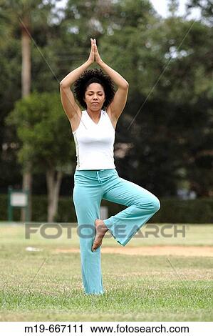 Woman doing yoga in a park View Large Photo Image Stock Image - Woman doing yoga in a park. Fotosearch