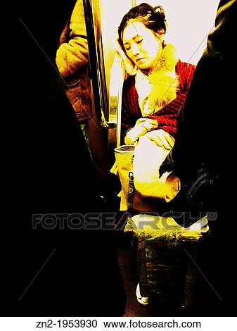 Stock Image - Woman dressed in Geisha sleeping in the subway, Tokyo, Japan.. Fotosearch