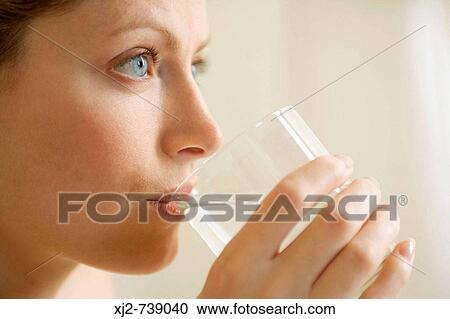 Woman drinking a glass of water View Large Photo Image Stock Image - Woman drinking a glass of water. Fotosearch