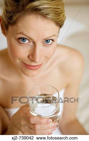 Stock Image - Woman drinking a glass of water. Fotosearch