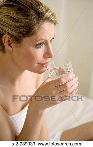 Woman drinking a glass of water View Large Photo Image Stock Photo - Woman drinking a glass of water. Fotosearch