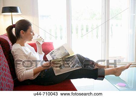 Woman drinking a milk glass reading a book relaxed on the sofa View Large Photo Image Stock Image - Woman drinking a milk glass reading a book relaxed on the sofa. Fotosearch