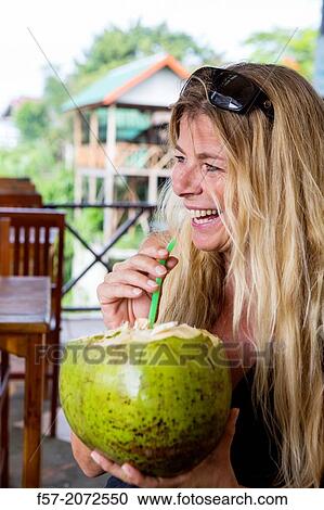 Woman drinking fresh coconut water in Vang Vieng, Laos. View Large Photo Image Stock Image - Woman drinking fresh coconut water in Vang Vieng, Laos.. Fotosearch